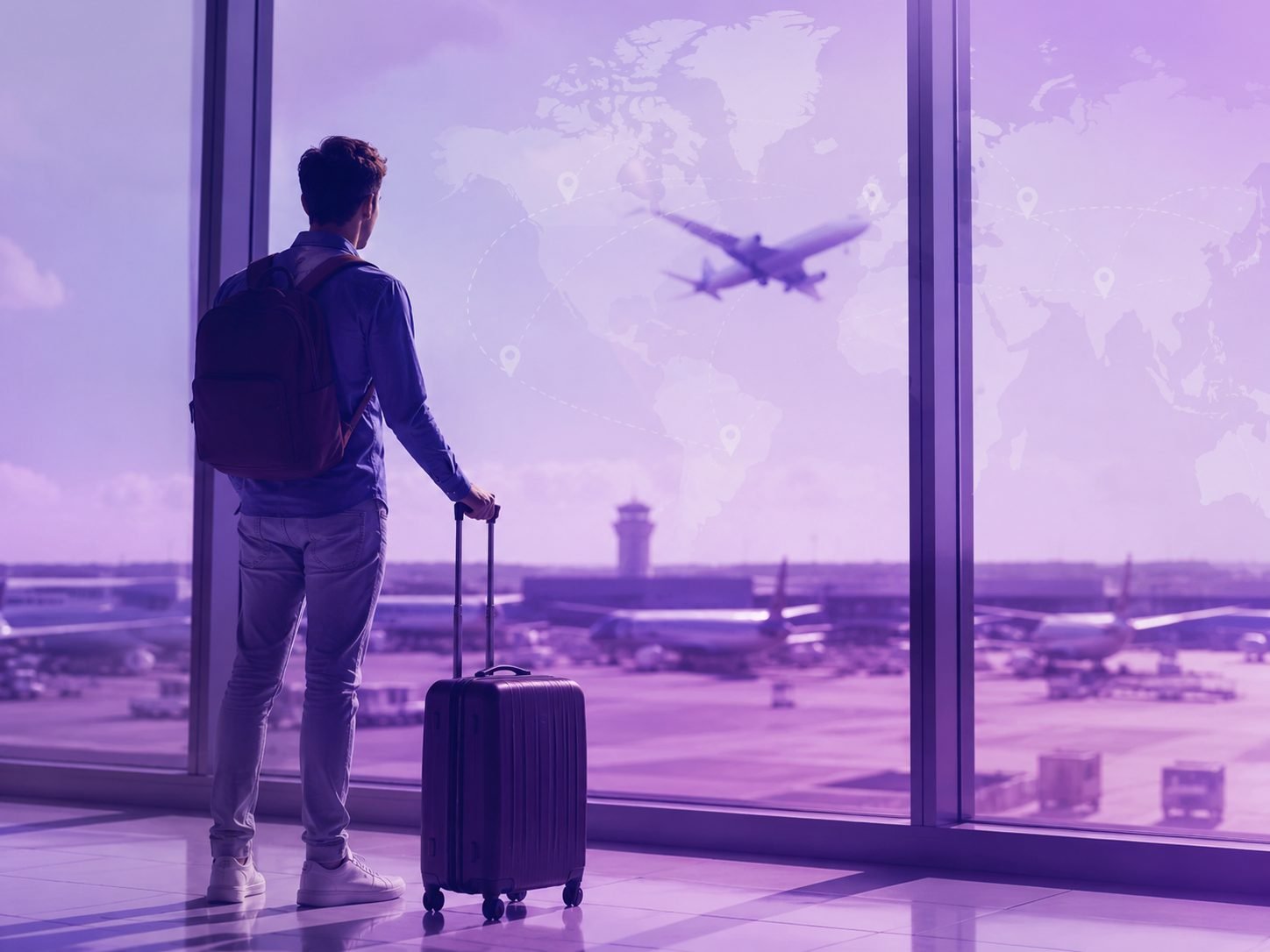 A traveler with a suitcase looking out at an airport departures board